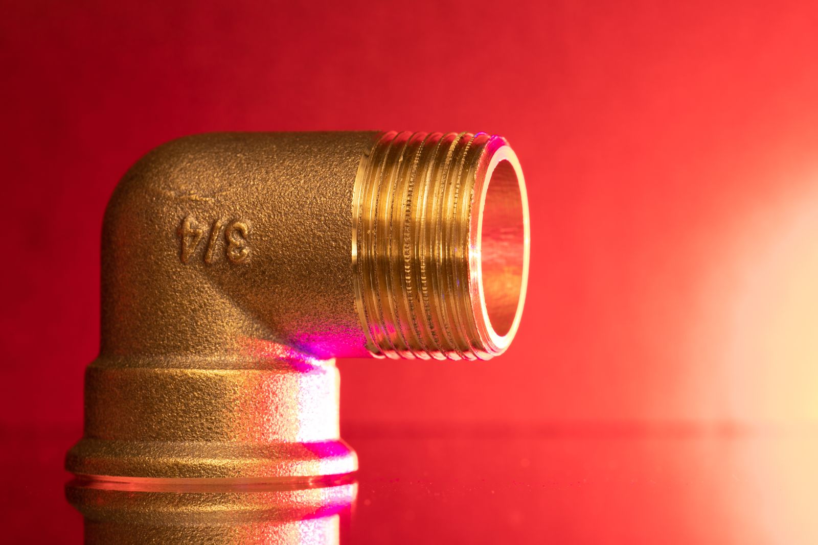 A brass elbow fitting marked with its size