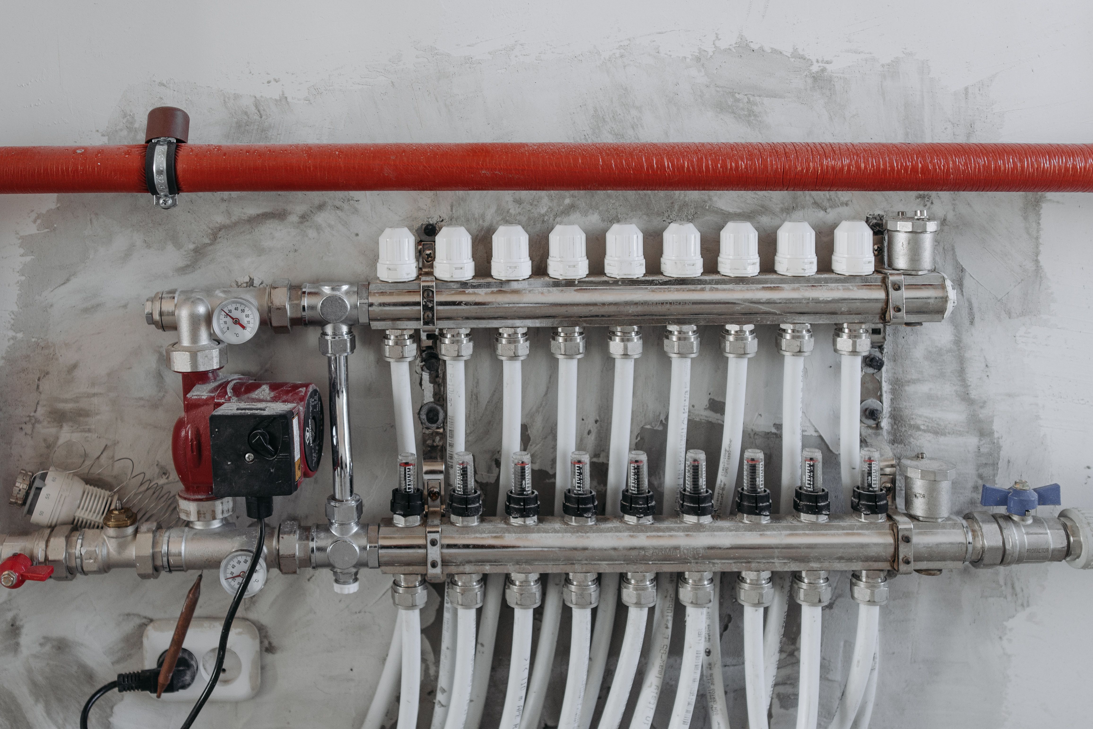 Gloved hands using spanners on a chrome fitting