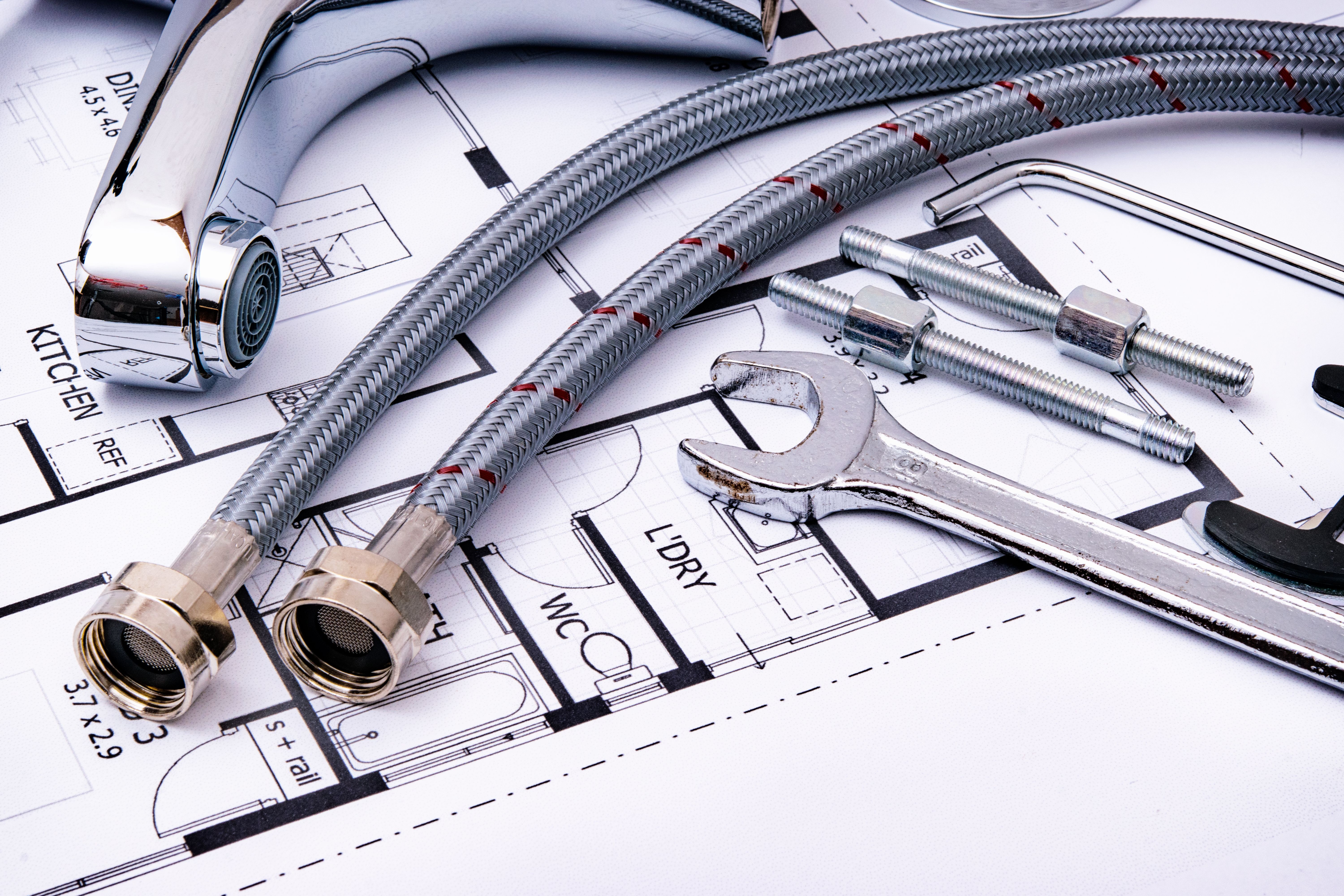 Gloved hands assembling a radiator with pipe wrenches