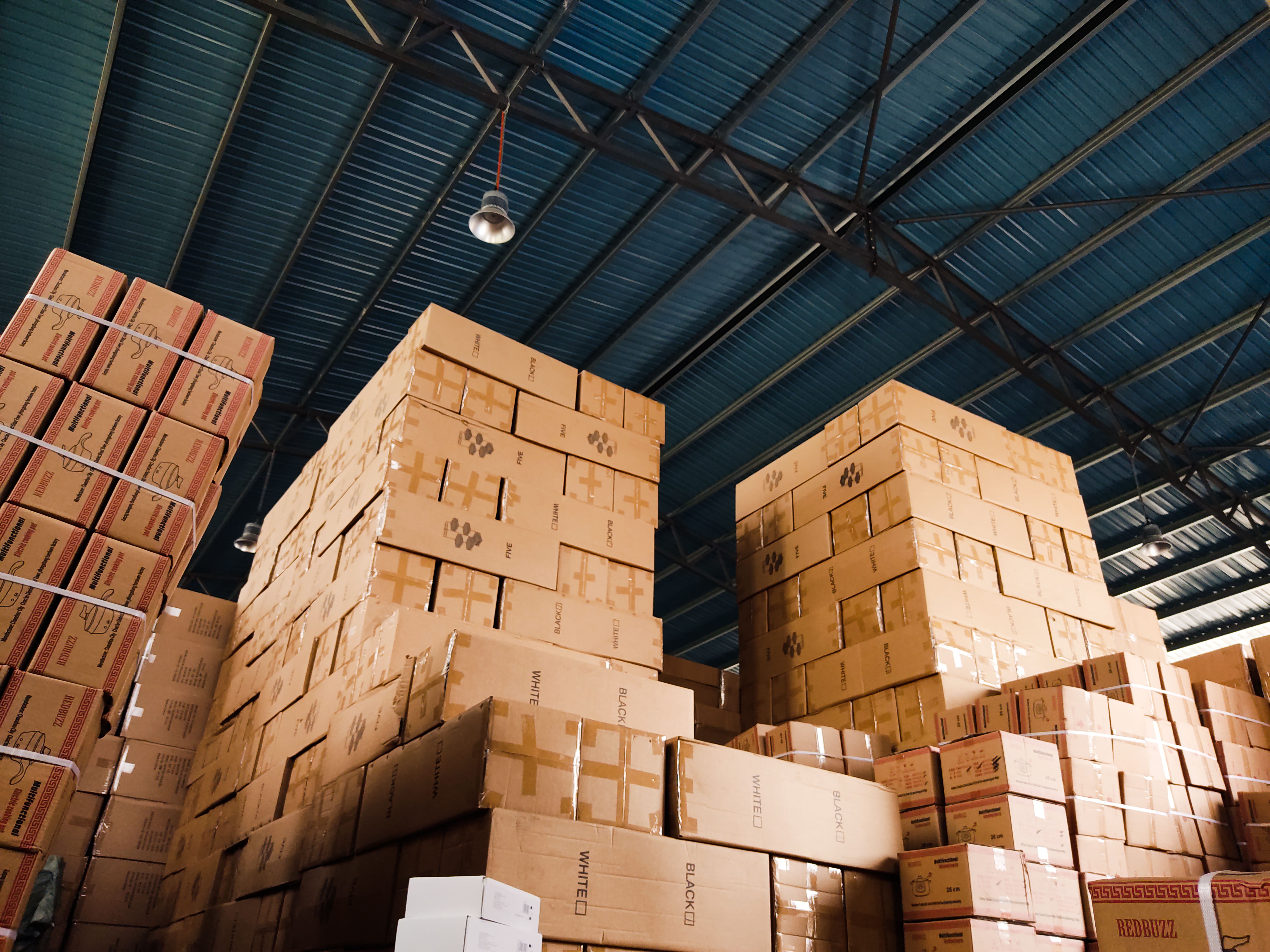 Dark warehouse aisle lined with tall racks of stock