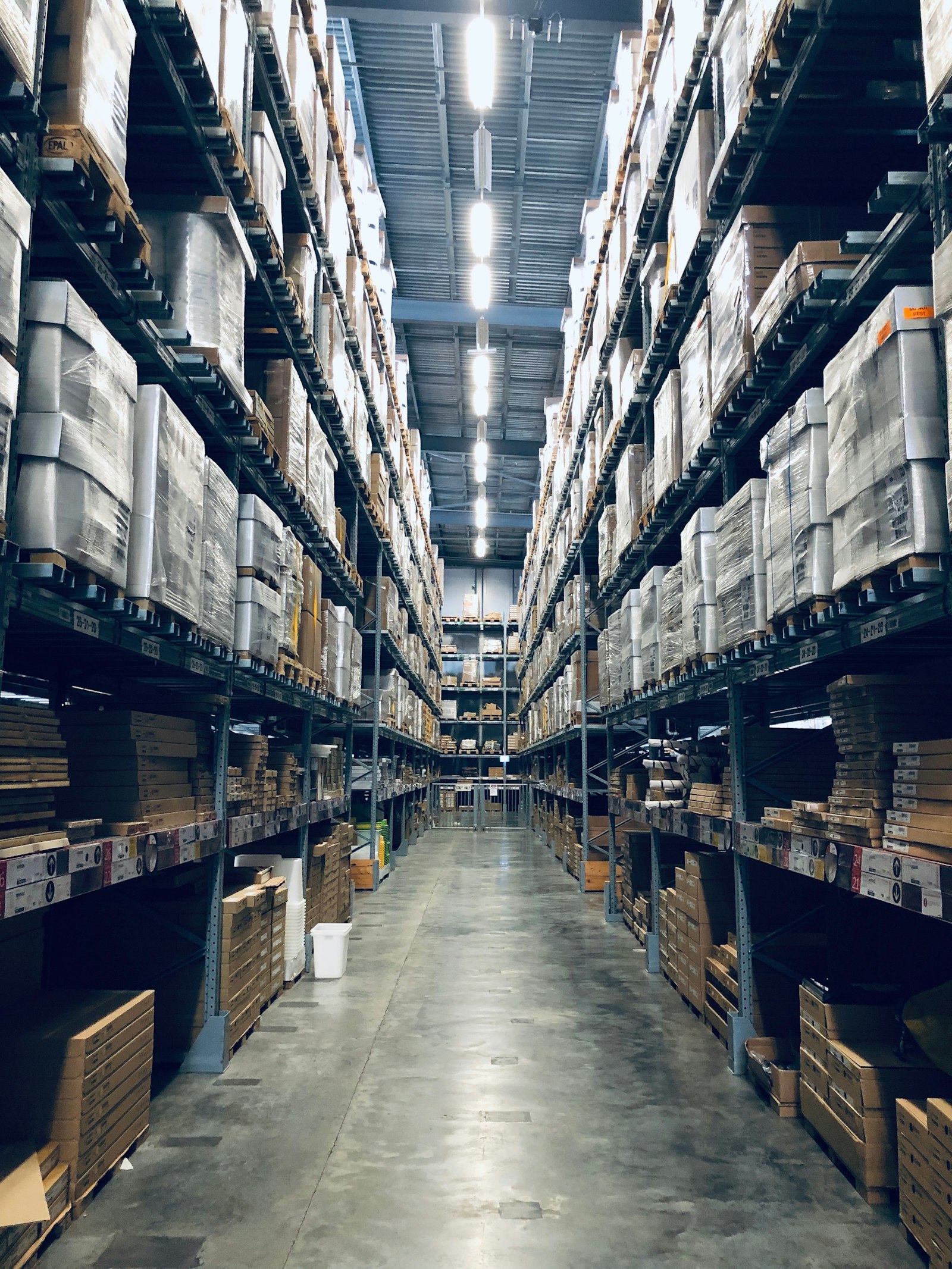 Warehouse aisle lined with tall stocked shelving